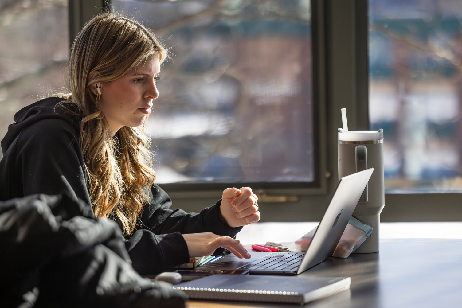 A student works on her laptop computer at a desk.