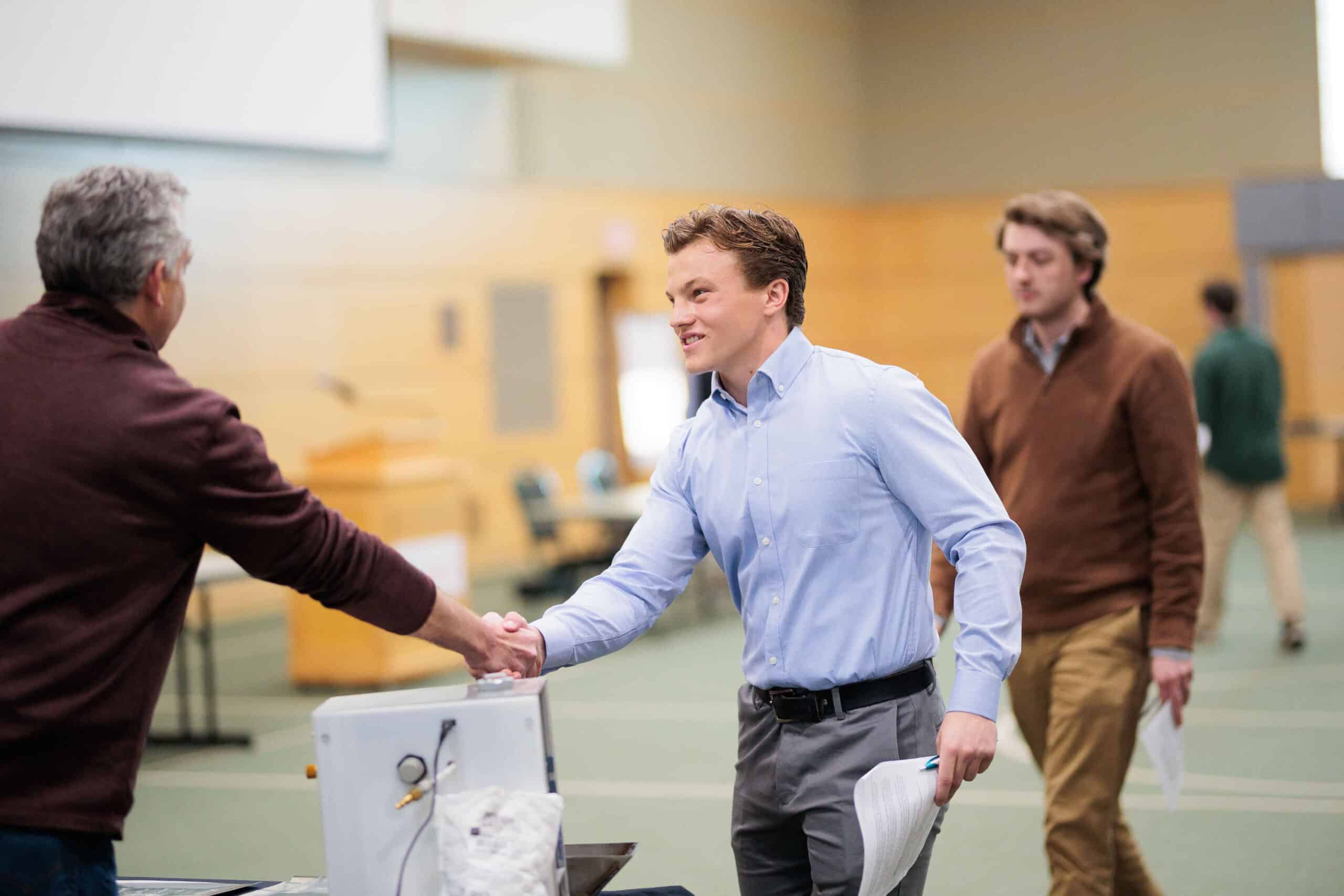 A young man shaking hands at a business presentation