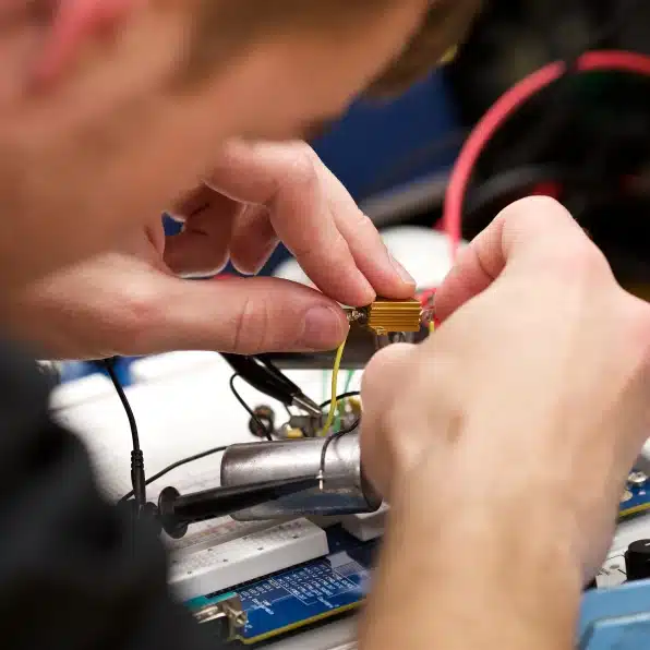 A person carefully working on electronic devices