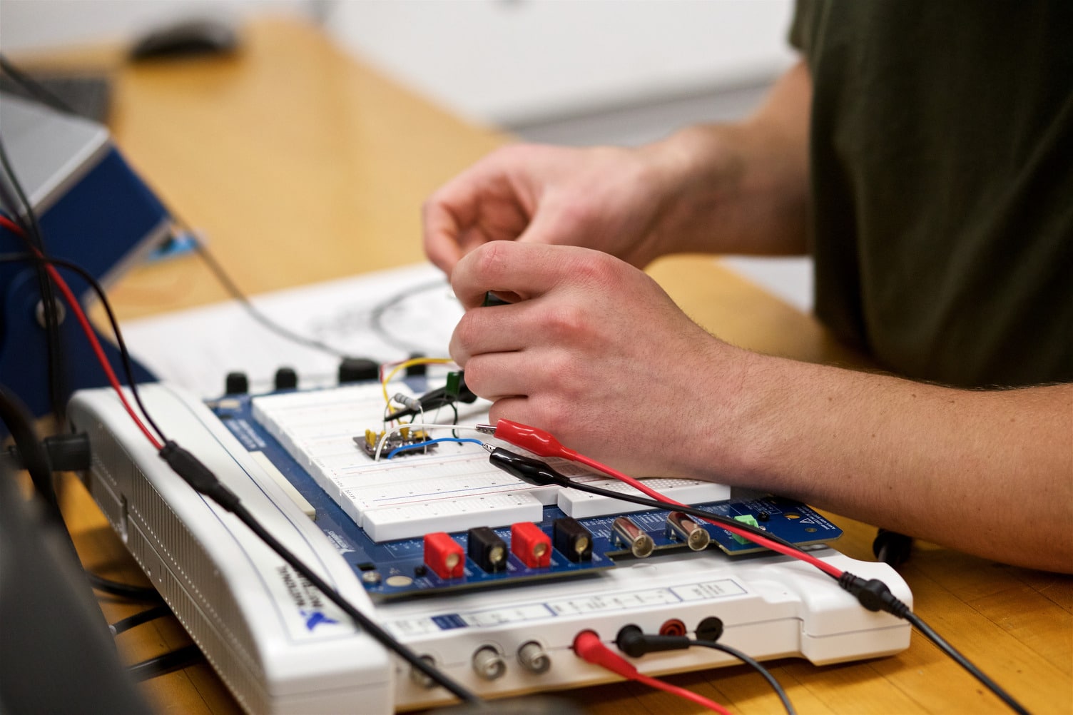 A close up photo of hands soldering an electrical component